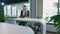 Elegant woman working in stylish office. Modern blond woman in trendy suit sitting at table in light contemporary office