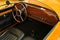 Elegant wooden interior, retro driving wheel and round analogue styled speedometer in microcar two seated microcar Patak Rodster