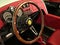 Elegant wooden steering wheel and vintage red dashboard of Vanderhall Venice Speedster, three-wheeled hand made autocycle.