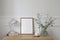 Elegant working space, home office. Cup of coffee, lamp, books. Empty vertical picture frame mockup on wooden desk