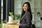 Elegant young Asian businesswoman in a formal suit sits in a coffee shop
