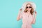 Elegant young attractive woman wearing pale pink summer dress, straw hat and sunglasses, thinking about her summer vacation.