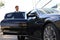 Elegant young businessman entering his car while standing outdoors