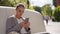 elegant young mixed race woman sitting on stone bench in city square, waiting for someone and using her phone. girl