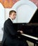 Elegant young pianist plays on grand piano