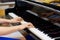 Elegant young woman hands playing the piano in a hall concert