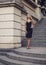 Elegant young woman standing on beautiful stairs outdoors