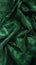 An elegantly draped piece of emerald green fabric with a subtle sheen and textured surface highlighted in the folds