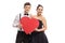 Elegantly dressed teenage couple holding a red heart