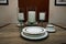 Elegantly set dining table with white plates and dishes