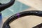 The element of the carbon-fiber steering wheel detail is stitched with violet thread from genuine leather of black color close-up