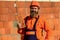 Element in masonry construction. Builder hold brick. Bearded man wear hard hat at construction site. Brick building