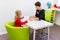 Elementary Age Girl in Child Occupational Therapy Session Doing Playful Exercises With Her Therapist.