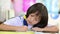 Elementary asian student girl doing homework or exam. Child learning, solved examples, doing exercises in school