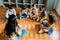 Elementary international students group sit cross legged in circle around the teacher and listening a story. Discussion group of