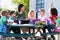 Elementary Pupils And Teacher Eating Lunch