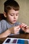 Elementary school age Caucasian child boy plays with plasticine on table, modeling clay, molds, sculpture