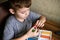 Elementary school age Caucasian child boy plays with plasticine on table, modeling clay, molds, sculpture