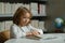 Elementary school boy. Little student on school library. Child reading book at school. Nerd pupil studying at school