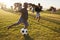 Elementary school kids playing football in a field