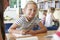 Elementary School Pupil Working At Desk In Classroom