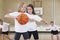 Elementary School Pupils Playing Basketball In Gym