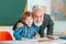 Elementary school. Smart pupil or schoolchild with senior teacher. Grandfather and son having fun together.