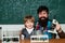 Elementary school teacher and student in classroom. Experiment. Teacher helping pupils studying at desks in classroom