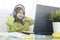 Elementary schooler girl in headphones sitting at desk on laptop - Smiling cute girl studying online from home and learning using