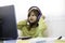 Elementary schooler girl in headphones sitting at desk on laptop - Smiling cute girl studying online from home and learning using