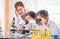 Elementary science class, Child girl looking at slides in through microscope, Science laboratory, Little kids with teacher in