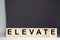 Elevate word written on wood block