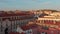 Elevated evening view of bright sun illuminated buildings downtown. Drone flying over red rooftops. Lisbon, capital of
