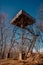 Elevated observation tower standing amongst a wooded landscape.