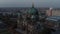 Elevated view of church with large green dome. Berlin cathedral at dusk. Large city in background. Berlin, Germany