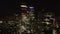 Elevated view of group of modern tall buildings in City financial and economic centre at night. Forwards fly towards