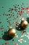 Elevated view of two Christmas golden copper decoration balls with red sequins glitter on a green background.