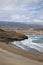 Elevated views of the empty beach and the spectacular volcanic coast with scattered wind turbines