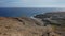 Elevated views from Pelada Mountain towards the small wild beach and the arid coastal landscape that surrounds it