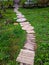An elevated wooden path curves through a green lawn