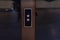 Elevator call buttons  on a brown wooden panel