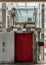 Elevator glass and chrome metal with closed red door in department store for lifting people to the upper floors with push switch