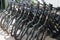 Eleven motorized black bicycles in a row