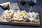 Elite cheeses: with truffle, dor blue, brie, parmesan and assortment of nuts on a wooden board. Appetizer for a wine party