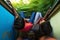 Ella, Sri Lanka 17 April 2018: Two teens riding on 2 class train and looking outside