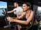 Elliptical walker trainer man and woman at black gym