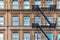 Ellow brick facade, and pair of boots hanging of the fire stairs. Chelsea, NYC