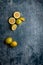 ellow and green lemons, cut and uncut, on a blue, dark, metallic, cement, marble, stone background