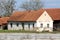 Elongated small old red bricks suburban family house with cracked facade and dilapidated wooden frame windows