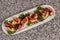 Elongated tray with Galician Octopus, with potatoes, paprika, olive oil on a granite background. Spanish ethnic cuisine concept